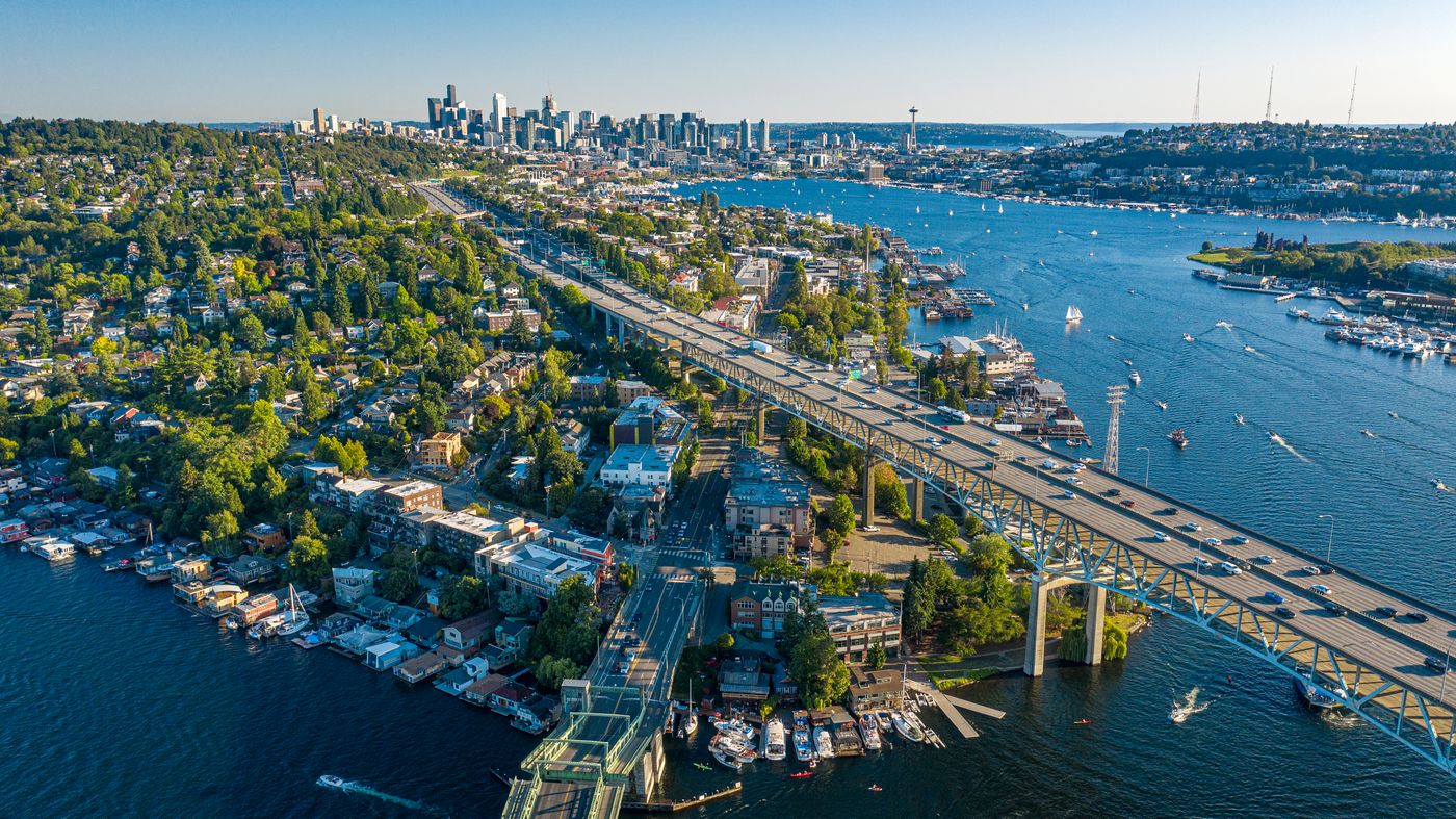 Aerial drone view of the downtown Seattle skyline with condominium towers, Elliott Bay, and the Puget Sound