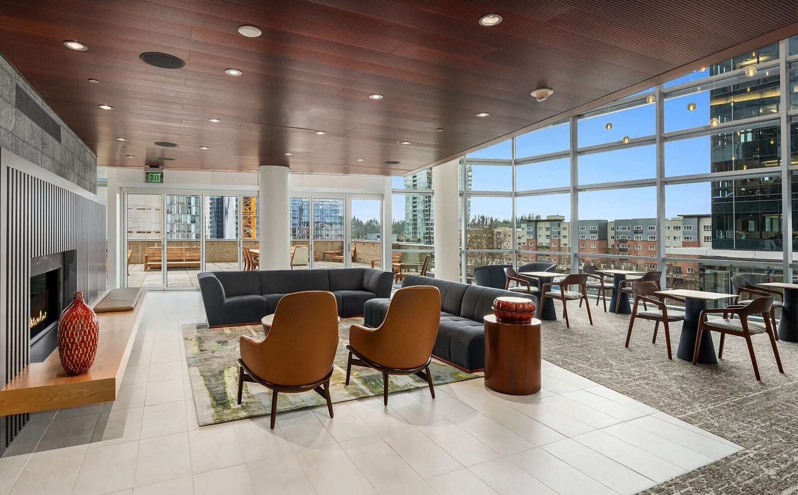 Resident lounge at Bellevue Towers with fireplace, floor-to-ceiling windows, and contemporary furnishings