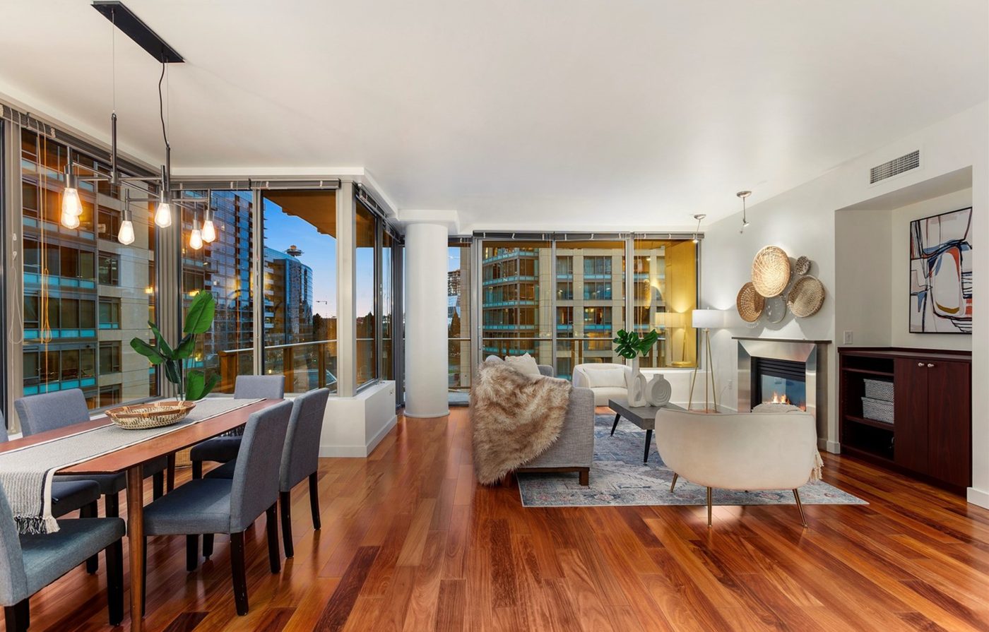 Open living and dining area with pendant lighting and fireplace