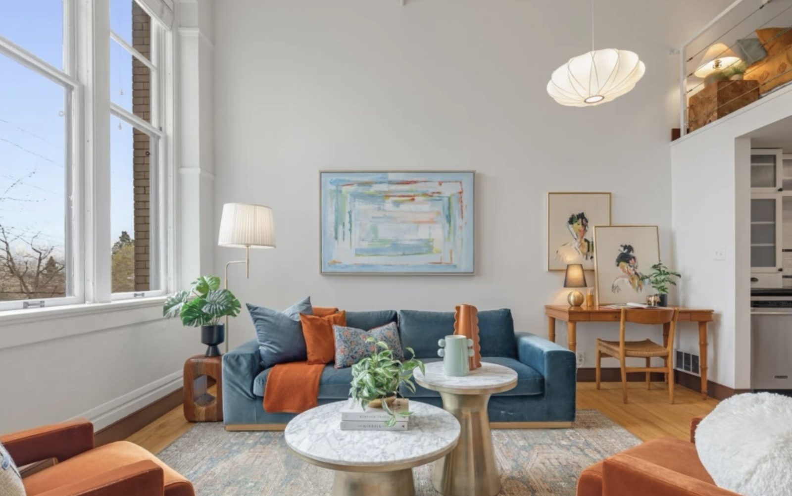 Living area of unit 436 with loft above and original hardwood floors