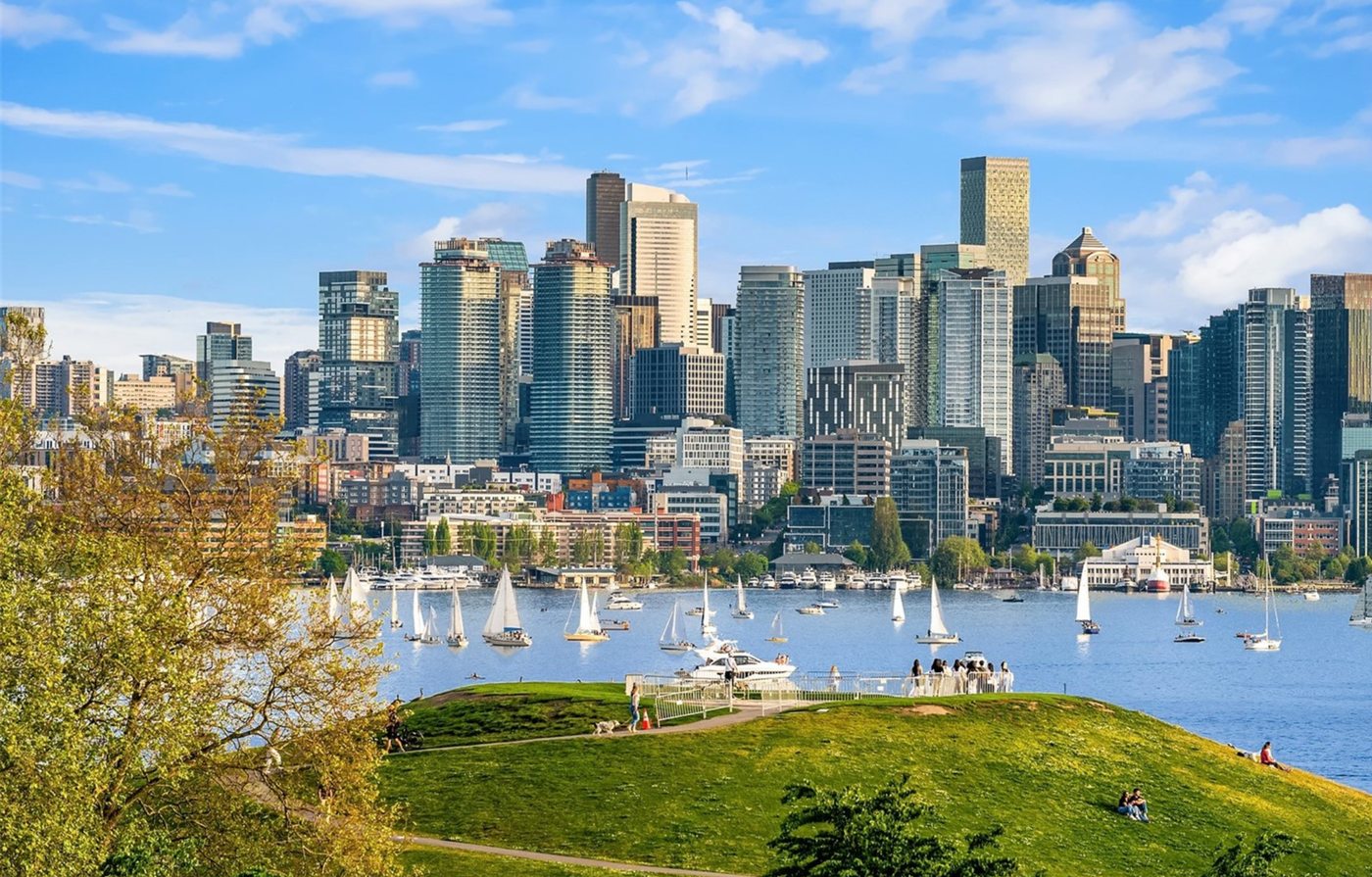 Dining area with lake and skyline views through floor-to-ceiling windows