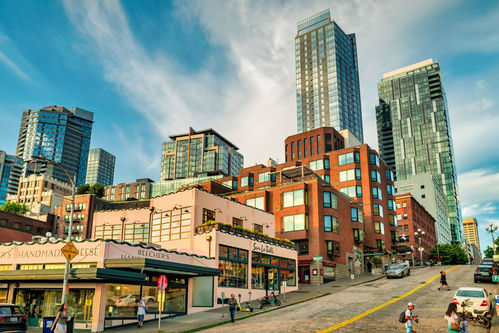 Historic brick buildings near Pike Place Market with modern Seattle condo towers rising behind